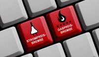 Auf einer Computertastatur befinden sich zwei rote Tasten. Die linke Taste trägt die Aufschrift „STROMPREIS-BREMSE“ mit einem Symbol eines Steckers. Die rechte Taste heißt „GASPREIS-BREMSE“ und zeigt eine Flamme. Beide Tasten stehen im Kontext von Preisdeckelmaßnahmen.