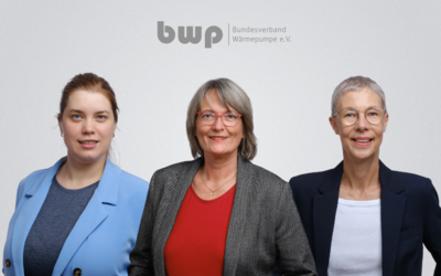 Drei Frauen stehen nebeneinander. Sie lächeln und tragen formelle Kleidung. Im Hintergrund ist das Logo des Bundesverbands Wärmepumpe e.V. sichtbar. Die Atmosphäre wirkt professionell und einladend.