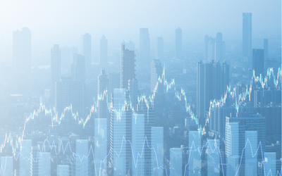 Silhouetten einer Stadt mit mehreren hohen Gebäuden im Hintergrund. Über der Skyline verläuft ein graphischer Verlauf, der steigende und fallende Werte darstellt, was auf wirtschaftliche oder finanzielle Daten hinweist. Die Bildstimmung ist subtil und futuristisch.
