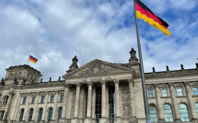 Deutscher Bundestag / Reichstag mit Inschrift: "Dem Deutschen Volke" und Deutschland-Flagge. Im Hintergrund blauer Himmel mit einzelnen Wolken.