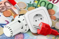 Ein Heizkörperthermostat, eine Steckdose und ein rotes Kabel mit Stecker liegen auf einem bunten Euro-Geldscheinen und Münzen. Die Gegenstände symbolisieren Energieverbrauch und Kosten.