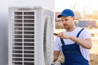 Ein Handwerker arbeitet an einer Klimaanlage. Er trägt eine blaue Kappe und einen blauen Overall. Mit einem Werkzeug in der Hand konzentriert er sich auf die Montage oder Reparatur der Geräte. Im Hintergrund ist eine helle, verschwommene Landschaft zu erkennen.