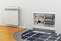 Das Bild zeigt einen Heizkörper an der Wand links und ein Heizungsverteilungssystem in einer Wandnische. Der Boden besteht aus einem gemischten Belag, wo Heizungsrohre verlegt sind, die aus schwarzen und weißen Komponenten bestehen.
