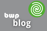 Logo eines Blogs mit dem Text "bwp blog" in großer, weißer Schrift auf grauem Hintergrund. Oben rechts befindet sich ein grünes Symbol mit einem spiralförmigen Muster.