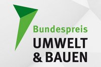 Logo für den Bundespreis Umwelt & Bauen, bestehend aus einem grünen Pfeil und den Texten „Bundespreis“ in Grün und „UMWELT & BAUEN“ in Schwarz. Der Fokus liegt auf nachhaltigem Bauen und Umweltschutz.
