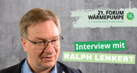 Porträt von Ralph Lenkert während eines Interviews. Im Hintergrund Informationen zu einem Forum über Wärmepumpen, das am 8. und 9. November 2023 in den Bolle-Festsälen stattfindet.