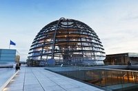 Die Reichstagskuppel in Berlin ist eine moderne Glaskonstruktion mit einer auffälligen Kuppelform. Sie bietet Besuchern eine Aussicht auf die Stadt und symbolisiert Transparenz und Offenheit in der Politik. Der Himmel ist klar und die Struktur reflektiert das Licht.