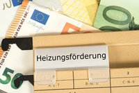 Ein Ordner mit dem beschrifteten Tab „Heizungsförderung“ liegt auf einem Untergrund aus verschiedenen Euro-Banknoten. Die Banknoten sind teilweise sichtbar und verleihen der Szene einen finanziellen Kontext.