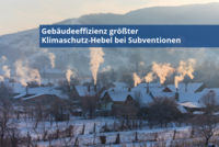 Eine winterliche Landschaft mit schneebedeckten Dächern von Gebäuden und aufsteigendem Rauch aus Schornsteinen. Der Text betont, dass die Gebäudeeffizienz der größte Hebel zum Klimaschutz bei Subventionen ist.