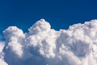 Himmelsbild mit großen, flauschigen, weißen Wolken vor einem klaren, blauen Himmel. Die Wolken haben eine weiche, voluminöse Struktur und scheinen in verschiedenen Formen angeordnet zu sein, was eine friedliche und beruhigende Atmosphäre vermittelt.